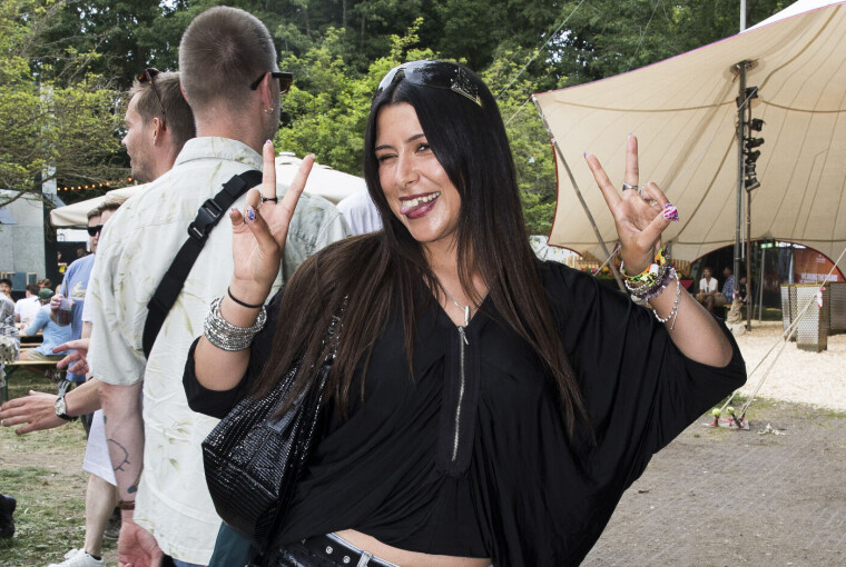 Smilende festivalgæst laver fredstegn på stien ved Roskilde Festival 2026.