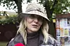 Kvinde med Gucci-hat og læderjakke interviewes udendørs på festivalplads.