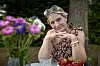 Annette Heick ved havesbord med jordbær og farverige blomster omkring sig.