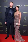 Erling Haaland og Isabel Haugseng Johansen står på rød løber foran Ballon d'Or-væg i Paris.