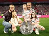 Harry Kane og hans familie poserer på banen med Bayern Münchens Meisterschale-trofæ.