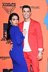 Georgina Rodríguez og Cristiano Ronaldo poserer på orange MTV EMAs 2019-bagvæg med logoer.