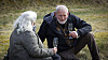 Lasse og kvinde sidder på græsset med champagneglas ved Næstrup Skyttecenter.