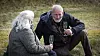 Lasse og kvinde sidder på græsset med champagneglas ved Næstrup Skyttecenter.