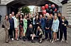 Holdfoto af Paradise Hotel 2021-deltagere til udendørs pressemøde med balloner i baggrunden