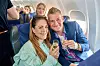 Camilla Dalsgaard og Anders Milholt skåler med drikkevarer i flysæder under en rejse.