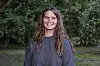 Charlotte fra ‘Landmand søger kærlighed’ 2026 står smilende i en grøn have.