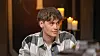 Sondre Slettemark ved et bord i et svagt oplyst studie med stearinlys bagved.