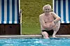 Richard Ragnvald sidder i badebukser ved kanten af en udendørs swimmingpool.