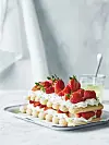 Kage i lag med friske jordbær og creme på en metalbakke.