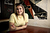 Stephanie Siguenza ved et cafébord foran farverig vægkunst i Slagelse