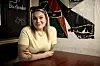 Stephanie Siguenza ved et cafébord foran farverig vægkunst i Slagelse