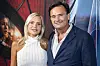 Par smiler foran Spider-Man-filmplakat ved premierearrangement