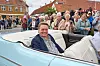 Mand i lyseblå veterancabriolet kører forbi publikum ved Rosenfestivalen i Bogense