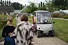 Elbil med passagerer kører på sti mellem besøgende i en botanisk have