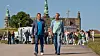 To mænd går på havnevej med Kronborg og filmhold i baggrunden under Sommerdahl-optagelse