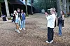 Unge står i skoven, mens en ven tager et billede af dem på en festivalplads