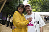 To smilende festivalgæster står arm i arm i skovområde på musikfestival.