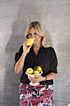 Eva Ravnbøl i sort bluse holder skål med citroner og dufter til en citron