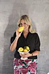 Eva Ravnbøl i sort bluse holder skål med citroner og dufter til en citron