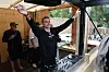 Jesper Buch spiller ved DJ-pulten i en åben træpavillon med publikum udenfor.