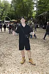 Festivalgæst i sort outfit og gule støvler poserer på skovsti under Smuk Festival.
