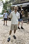 Abdel Aziz Mahmoud står foran en træbygning på Smukfest omgivet af festivalgæster.