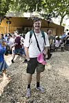 Victor Lander står på Smukfest 2026 dag 1 omgivet af festivalgæster og boder i skyggefuldt skovområde.