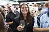 Smilende festivalgæst med glas hvidvin midt i en tæt menneskemængde på Smuk Festival.