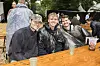 Unge festivalgæster i regnslag smiler ved et vådt bord på Smukfest dag 2 2026