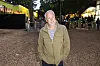 Mand står foran indgangen til SMUK Festival dag 2 2026 med oplyste boder bagved.