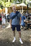Mand står og smiler blandt gæster på Smukfest 2026 i skoven.