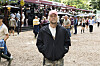 Mand i sort jakke står på grusplads blandt festivalgæster på Smukfest dag 3 2026.