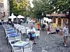 Brostensbelagt gade i Skadarlija med caféborde og gående gæster mellem restauranter.