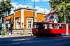 Rød sporvogn passerer en orange historisk bygning i Dorćol i Beograd