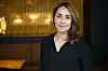 Sofie Gråbøl står indendørs foran varmt oplyst baggrund under støttekoncert