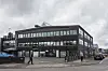 Mørk kontorbygning på gadehjørne i Helsingør med gående fodgængere foran.
