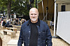 Festivalgæst i denimjakke står i et træbeklædt område på Smukfest dag 3.