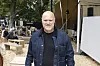 Festivalgæst i denimjakke står i et træbeklædt område på Smukfest dag 3.