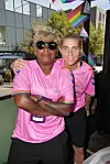 To i pink trøjer står tæt sammen ved et udendørs pride-arrangement.