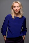 Kvinde står foran neutral baggrund og ser roligt mod kameraet.