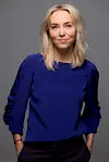 Kvinde står foran neutral baggrund og ser roligt mod kameraet.
