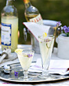 To glas lys drink med citron og lavendel på sølvbakke på udendørs bord