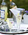 To glas lys drink med citron og lavendel på sølvbakke på udendørs bord