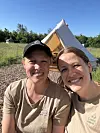 To personer i GLAMPING t-shirts foran et lyst glamping-telt i grønt landskab