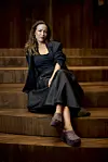 Maria Lucia sidder afslappet på de brede trætrin i Østre Gasværk Teater under pressemøde.