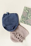 Hæklede babyshorts i blå og rosa ved siden af blomsterdekoreret notesbog