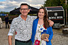 To gæster står og smiler ved Reality Awards Sommerfest 2026 foran Royal Beer-logo