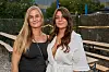 To kvinder står og smiler ved langborde til Reality Awards Sommerfest 2026