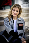 Sarah Grünewald sidder på en stentrappe ved Bernstorff Slot under et pressemøde.